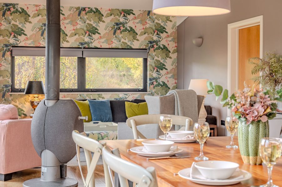 Dining space in Flora lodge at Brompton Lakes with wooden table and pendant lighting.