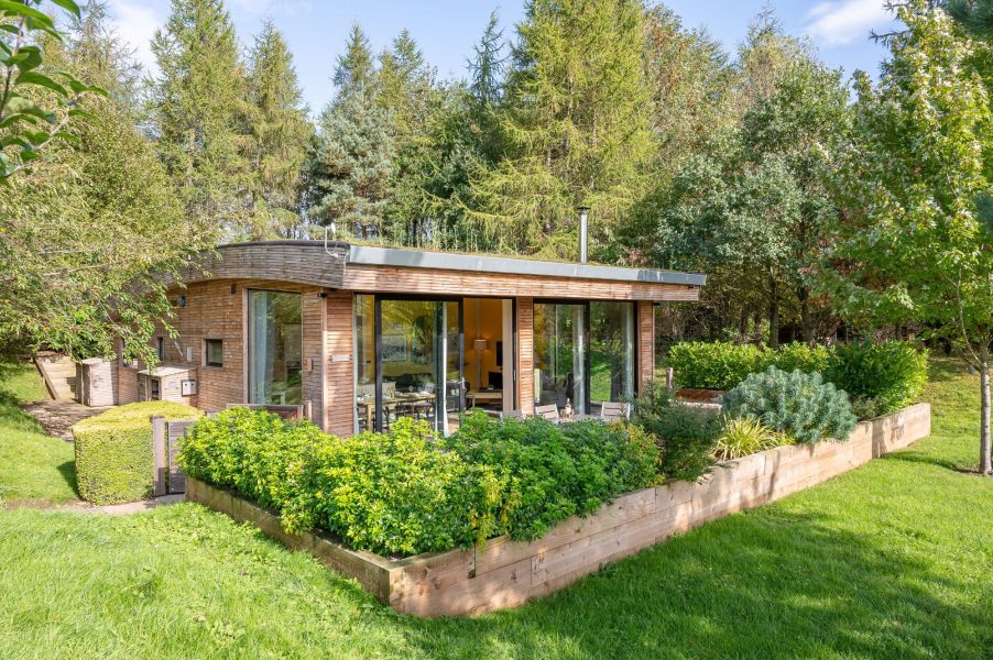 Exterior of Percy lodge with patio dining area at Brompton Lakes, near Richmond Yorkshire.
